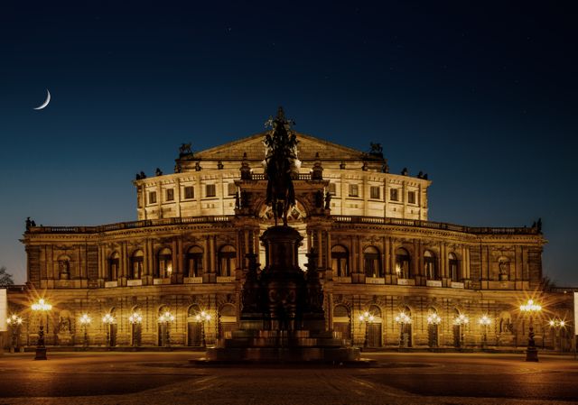 Magnificent view of illuminated opera house at night with a crescent moon in a clear sky. The perfect reference for content related to travel, culture, historical landmarks and urban architecture. Ideal for promoting tourism, featuring in architectural studies, or enhancing blogs focused on European destinations.