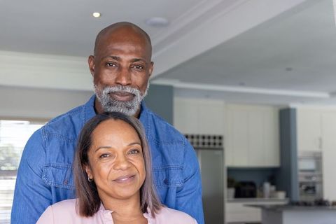 Mature couple embracing and smiling in modern kitchen cozy lifestyle portrait