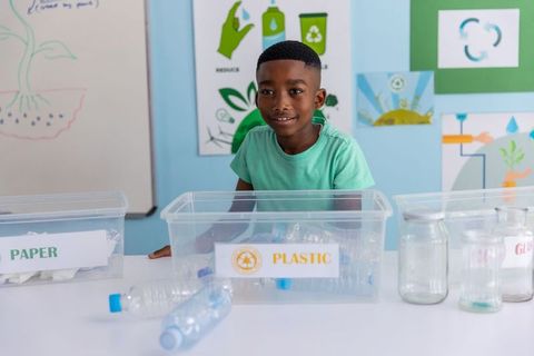 African american student sorting plastic bottles in classroom recycling activity for kids