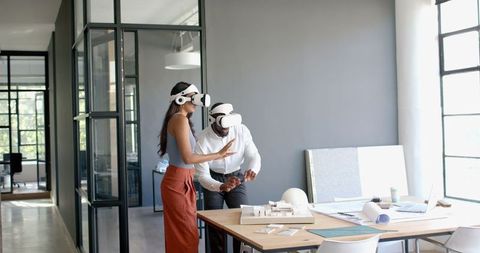 Diverse Colleagues Using VR Headsets for Architectural Project Collaboration