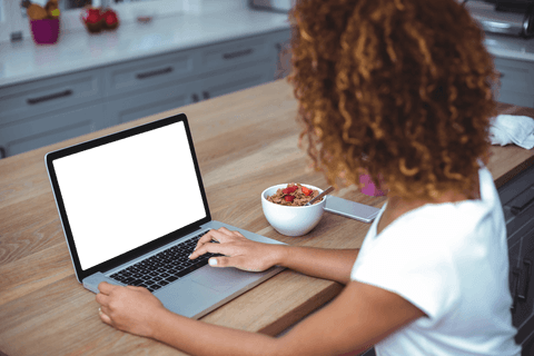 Transparent laptop screen in modern kitchen with woman