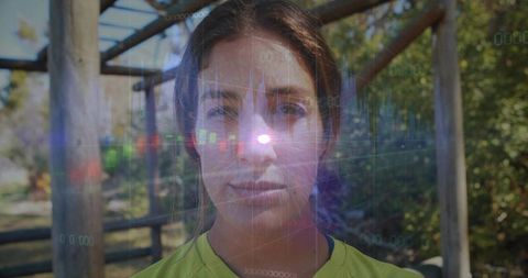 Female athlete portrait with holographic data overlay and sun flare in park