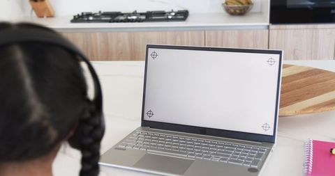 Biracial Girl Using Laptop for Online Learning in Modern Kitchen