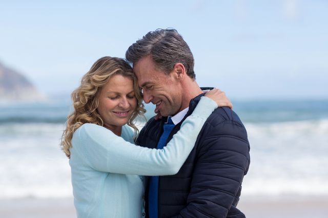 Suitable for illustrating romance, love, and relationships in mature couples. Perfect for use in advertisements, blogs, websites, or magazines focused on travel, relationships, or lifestyle content. Depicts a warm, affectionate moment between a couple by the ocean, highlighting emotional connection and joy.