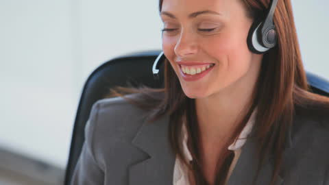 Smiling Businesswoman Using Headset in Office