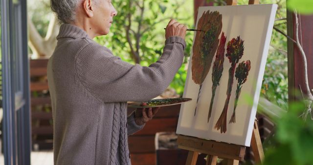 Senior adult woman painting on canvas in outdoor garden - Download Free Stock Images Pikwizard.com