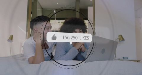 Young men watching laptop together with social media likes overlay in modern bedroom