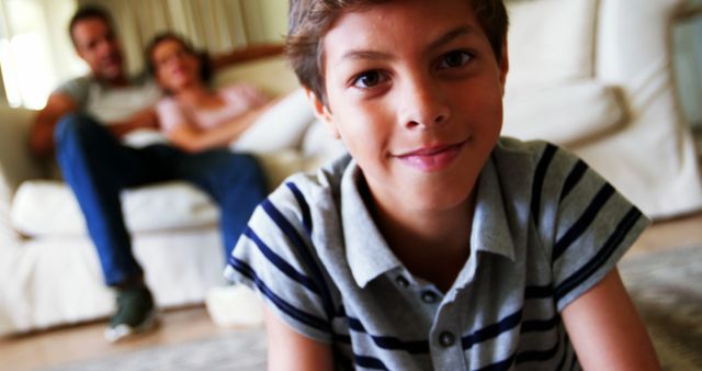 Smiling Boy Relaxing at Home with Family in Background - Download Free Stock Images Pikwizard.com