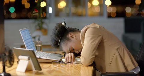 Exhausted Businesswoman Sleeping at Desk After Long Day at Work