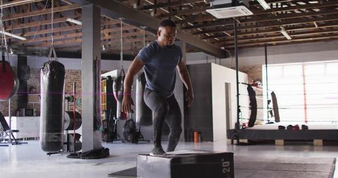 Male Athlete Practicing Plyometric Jumps at Industrial Style Gym