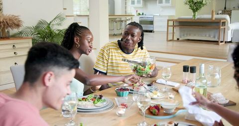 Diverse Friends Sharing Laughter and Dinner Indoors