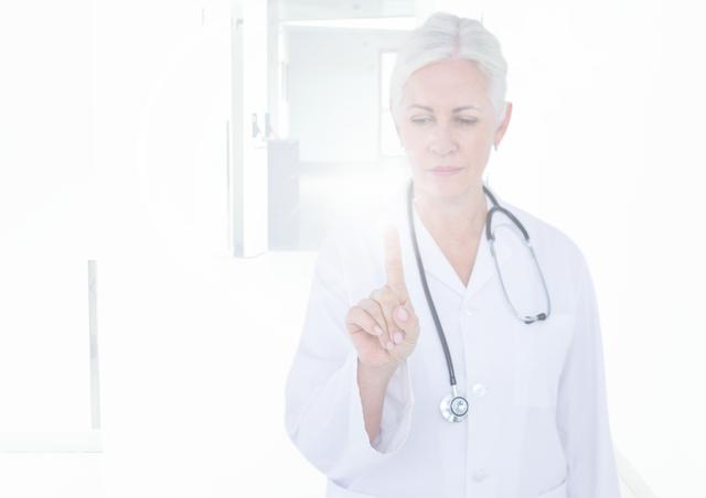 Senior female doctor interacting with invisible digital screen in bright, modern healthcare environment. Holding stethoscope, signifying blend of technology and human touch in medical care. Suitable for topics on telemedicine, healthcare technology, modern hospitals, medical advancements, and futuristic healthcare.