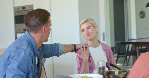 Couple sharing warm moment during family meal in bright modern kitchen