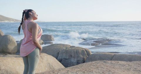 Woman Stretching Neck by Ocean Waves in Tranquil Setting