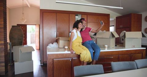 Diverse Female Couple Smiling Together in Modern Kitchen