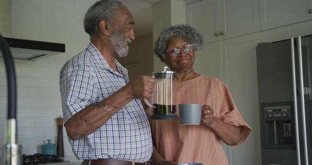 Image of african american senior couple making coffee and talking together in kitchen. healthy, active retirement lifestyle at home.