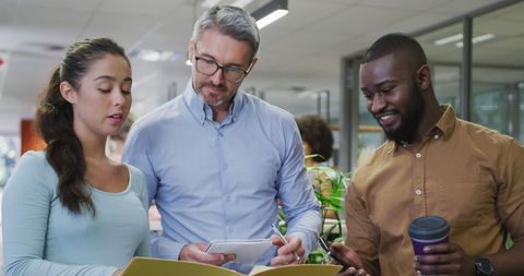 Diverse colleagues discussing documents in modern office environment