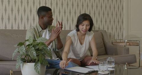 Happy couple planning wedding details in living room
