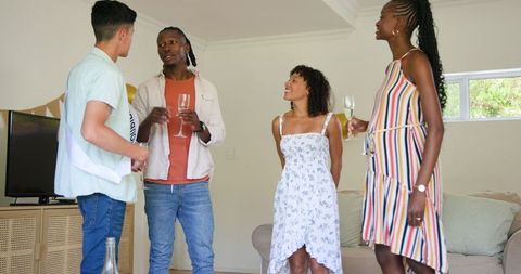 Friends Celebrating with Drinks and Smiles at Birthday Party