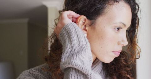 Thoughtful Woman Gazing Outside with Pensive Expression