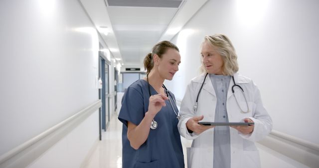 Healthcare Professionals Discussing Patient Data in Hospital Corridor - Download Free Stock Images Pikwizard.com