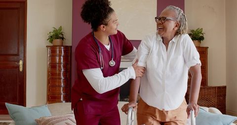 Healthcare Worker Assisting Senior Woman with Walker at Home