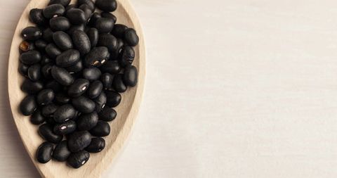 High Angle View of Black Beans in Wooden Spoon on White Background - Download Free Stock Images Pikwizard.com