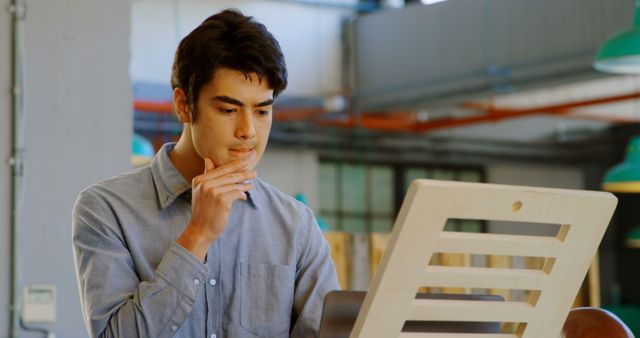 Thoughtful Man Pondering Work at Office Desk in Modern Workspace - Download Free Stock Images Pikwizard.com