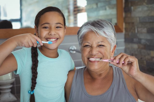 Grandmother and granddaughter brushing teeth in the bathroom at home