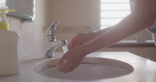 Senior Washes Hands with Tap Water in Sunlit Bathroom - Download Free Stock Images Pikwizard.com