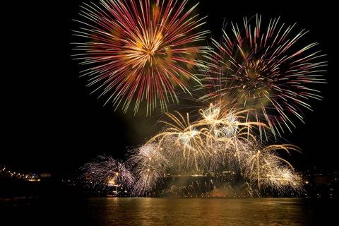 Colorful Firework Display Over Water During Night Celebration