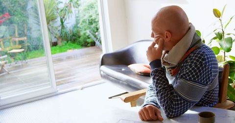 Contemplative man in cozy home environment near window
