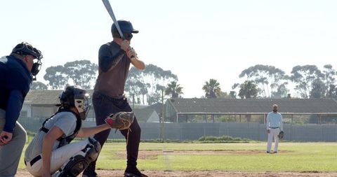 Batter at Home Plate with Catcher and Umpire on Sunny Baseball Diamond with Pitcher