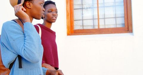 Twin sisters walking together in urban setting