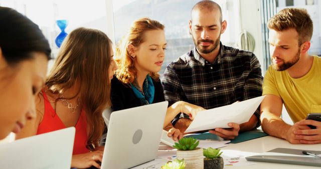 Team Collaboration in Modern Office With Documents and Laptops - Download Free Stock Images Pikwizard.com