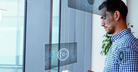 Professional middle eastern man engages with holographic panels in tech office