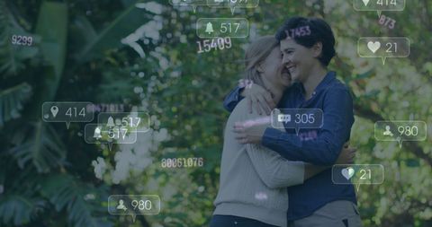 Loving lesbian couple hugging in park with social media icons
