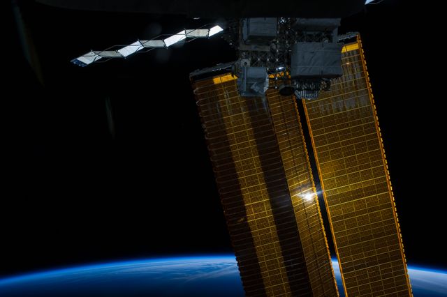 ISS040-E-007073 (3 June 2014) --- Some 228 nautical miles above the home planet, one of the Expedition 40 crew members aboard the International Space Station photographed this view of a sun-kissed solar array wing and a photovoltaic radiator (top) on the orbital outpost on June 3, 2014.