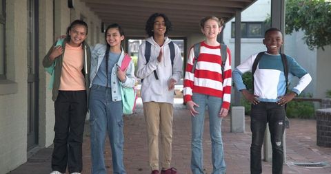 Diverse Schoolchildren Holding Backpacks on Outdoor School Walkway