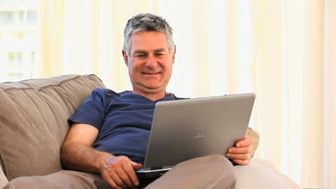 Man Relaxing at Home Enjoying Laptop