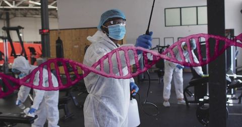 Disinfecting gym equipment in ppe with dna helix overlay conveying biosecurity and safety