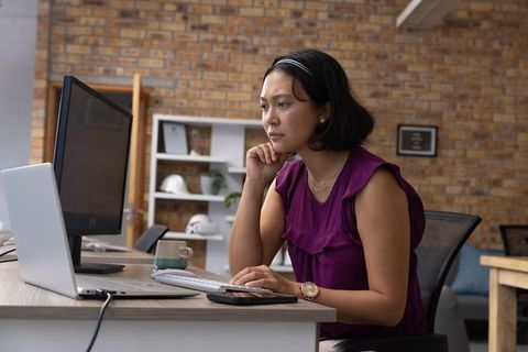 Asian businesswoman focused on work at modern office desk