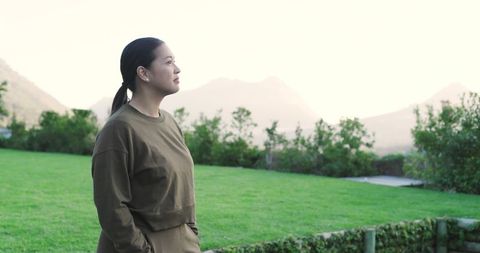 Woman in tranquil outdoors gazing at misty mountain landscape