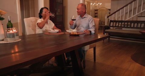 Senior Couple Enjoying Dinner in Cozy Dining Room Interior