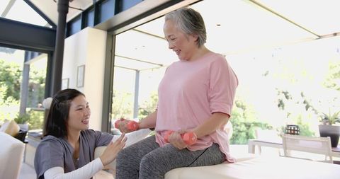 Senior Asian Woman Exercising with Physiotherapist Assistance
