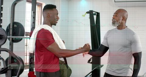 Two men clasping forearms at gym celebrating workout partnership, teamwork, strength