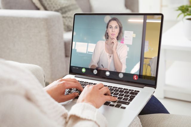 Caucasian businesswoman using laptop during video conference with caucasian female colleague. unaltered, work from home, business, wireless technology, working, teamwork and office concept.