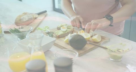 Slicing lemon wedges and assembling avocado toast on marble counter for sunny home brunch