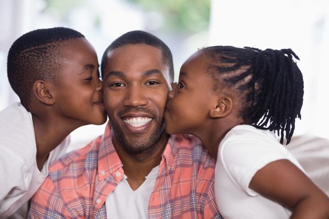 Father enjoying affectionate moment with children at home. Perfect for family-oriented advertisements, parenting blogs, and social media posts celebrating family bonds and love.