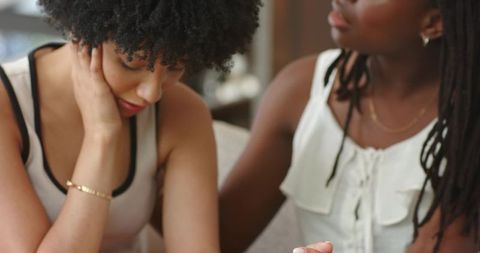 African american women comforting each other on sofa offering emotional support and empathy